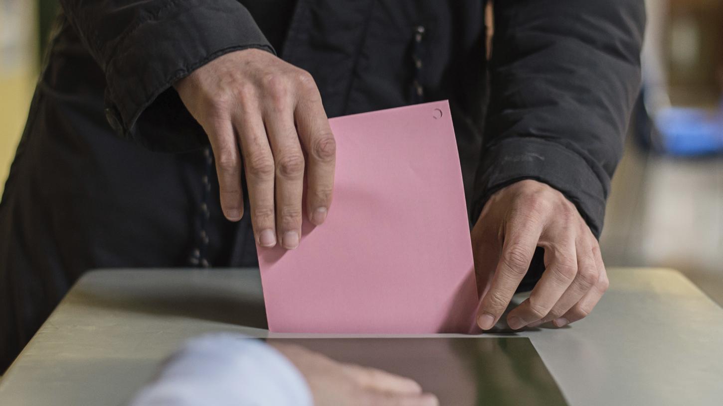 Ein Mann wirft einen Stimmzettel in eine Wahlurne. Am 8. Oktober 2023 sind die Bürger in Bayern aufgerufen, einen neuen Landtag zu wählen.