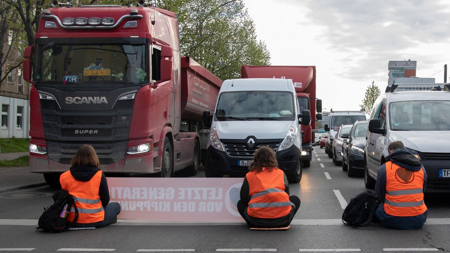 Aktivisten der Gruppierung Letzte Generation blockieren eine Kreuzung an der Landsberger Allee in Berlin.
