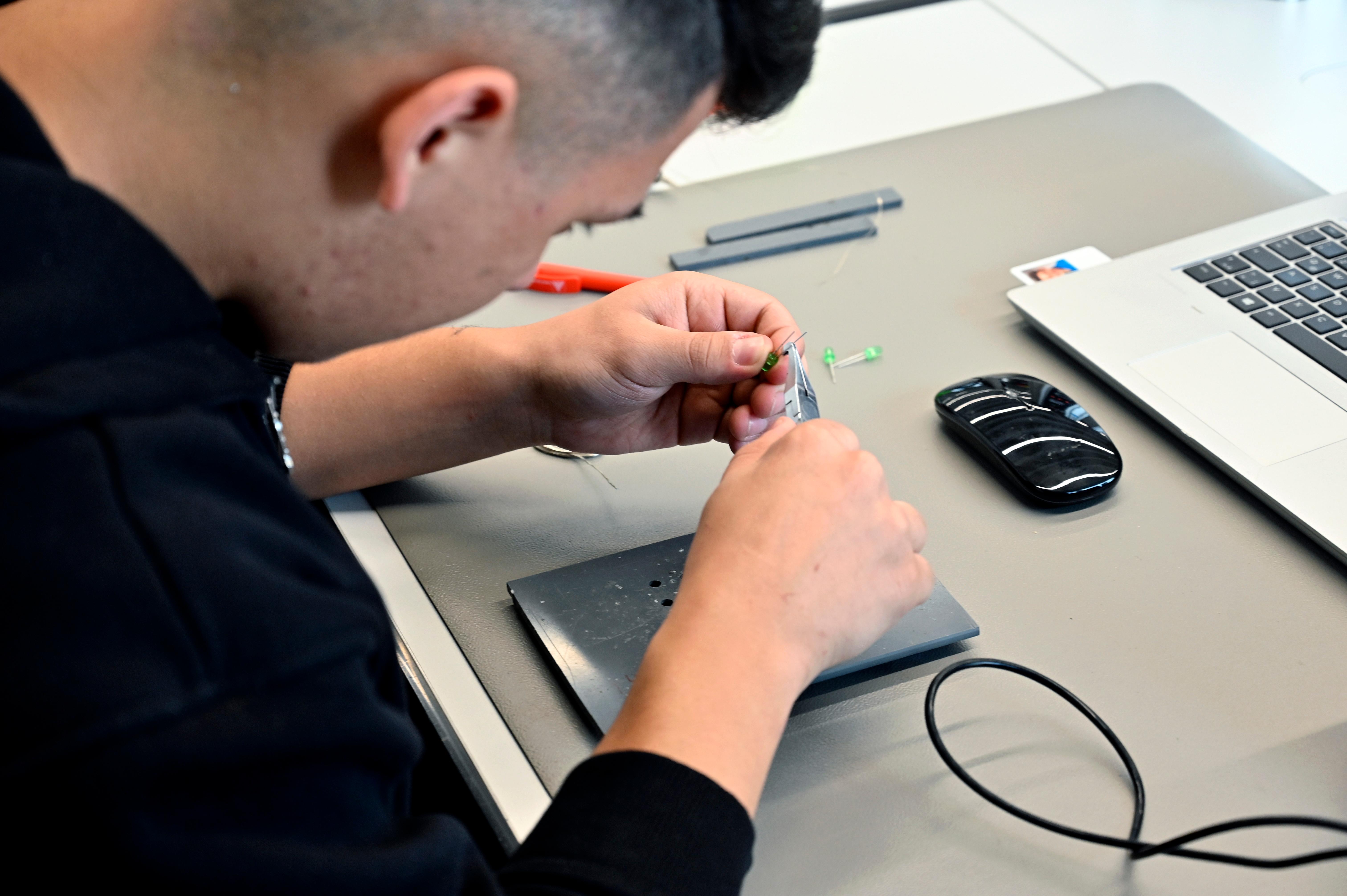 Hier arbeitet ein Auszubildender mit Leuchtdioden an einer elektronischen Schaltung.  