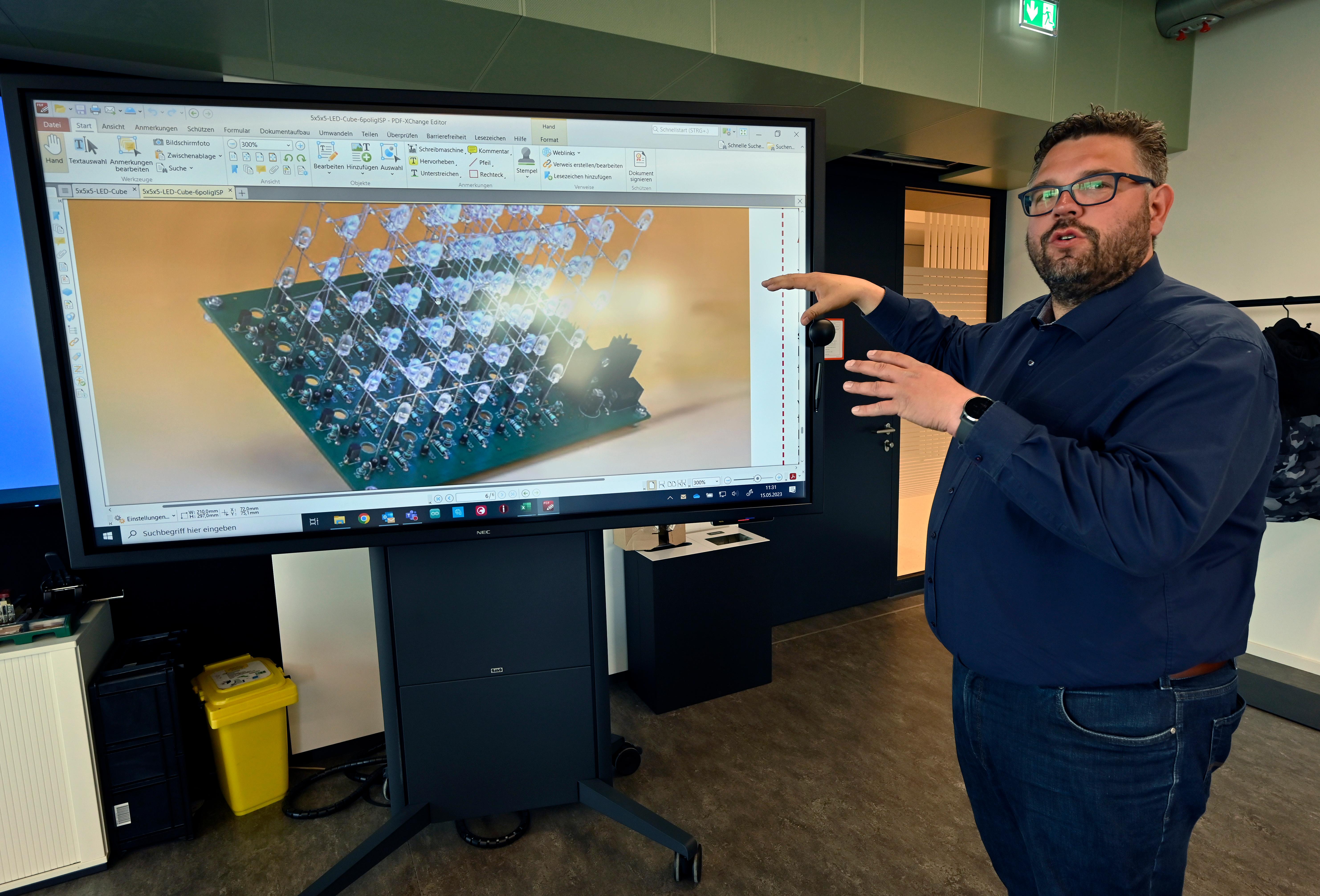 Marco Friepes vor dem Bild einer LED-Schaltung.  