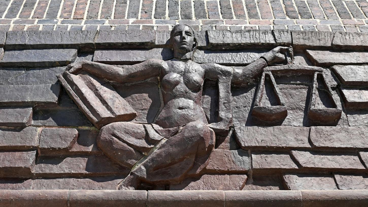 Blick auf die Justitia über dem Eingang eines Landgerichts.