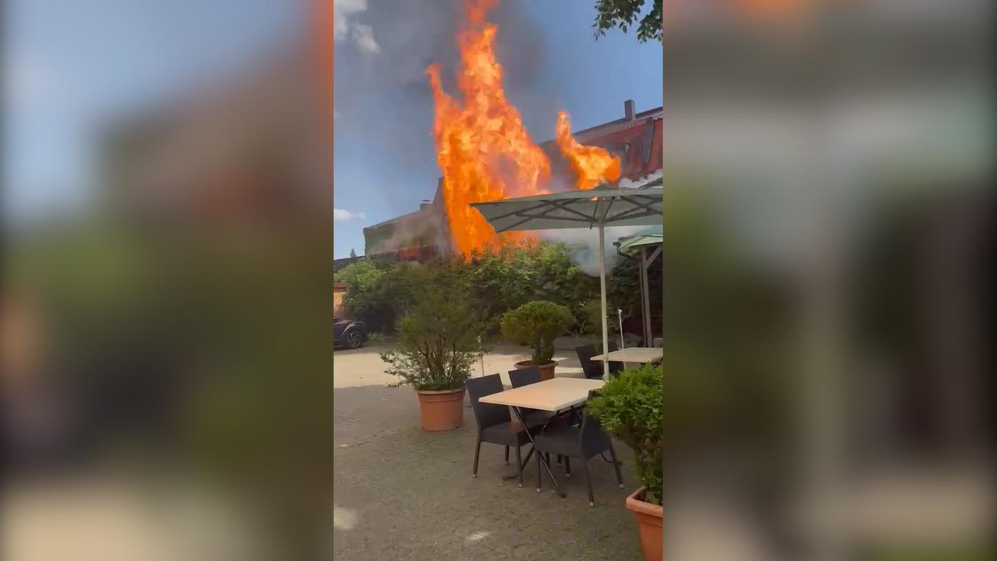 Dieses Bild zeigt, wie die Flammen aus dem benachbarten Garagenhof auf den Außenbereich des Restaurants übergreifen.