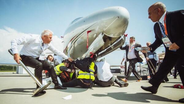 Am Dienstag ketteten sich mehrere Klimaaktivisten an Privatjets. Damit wollten sie auf die Belastung der Privatfliegerei auf die Umwelt aufmerksam machen. Am Dienstag ketteten sich mehrere Klimaaktivisten an Privatjets. Damit wollten sie auf die Belastung der Privatfliegerei auf die Umwelt aufmerksam machen.