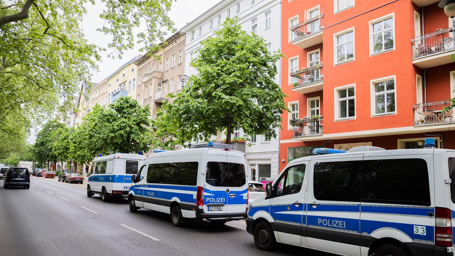 Polizeifahrzeuge stehen bei einer Hausdurchsuchung in Berlin-Kreuzberg in einer Straße.