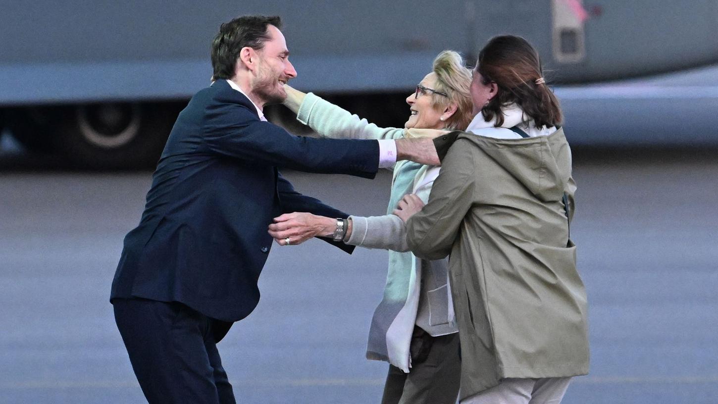 Olivier Vandecasteele (l) trifft seine Familie bei der Ankunft auf dem Militärflughafen Melsbroek.