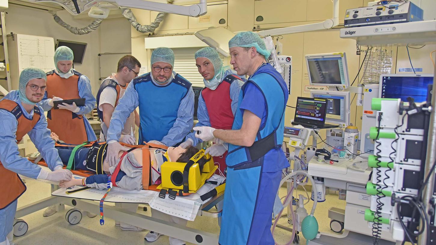 Prof. Mario Perl (3. v. r.) und ein interdisziplinäres Notfallteam simulieren im Rahmen einer regelmäßigen Übung die Erstversorgung eines Schwerstverletzten in einem Schockraum des Uniklinikums Erlangen. 