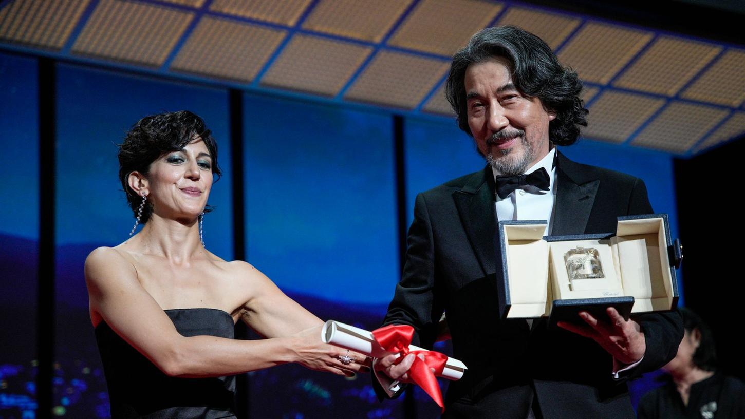 Zahra Amir Ebrahimi (l) überreicht Koji Yakusho den Preis als bester Schauspieler für seine Rolle im Film "Perfect Days" von Regisseur Wenders.