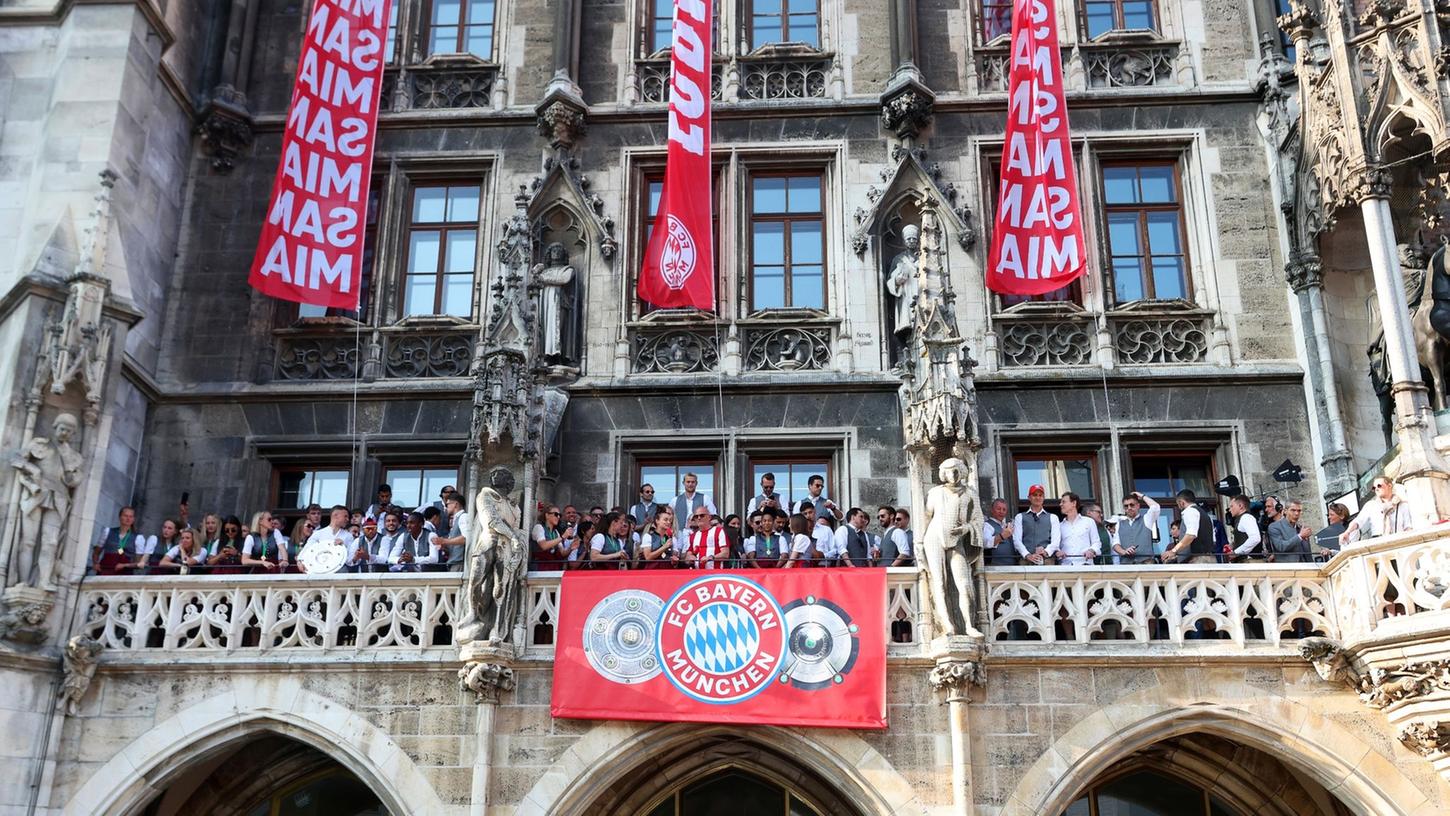 Die Spielerinnen und Spieler des FC Bayern feiern gemeinsam auf dem Rathaus-Balkon.