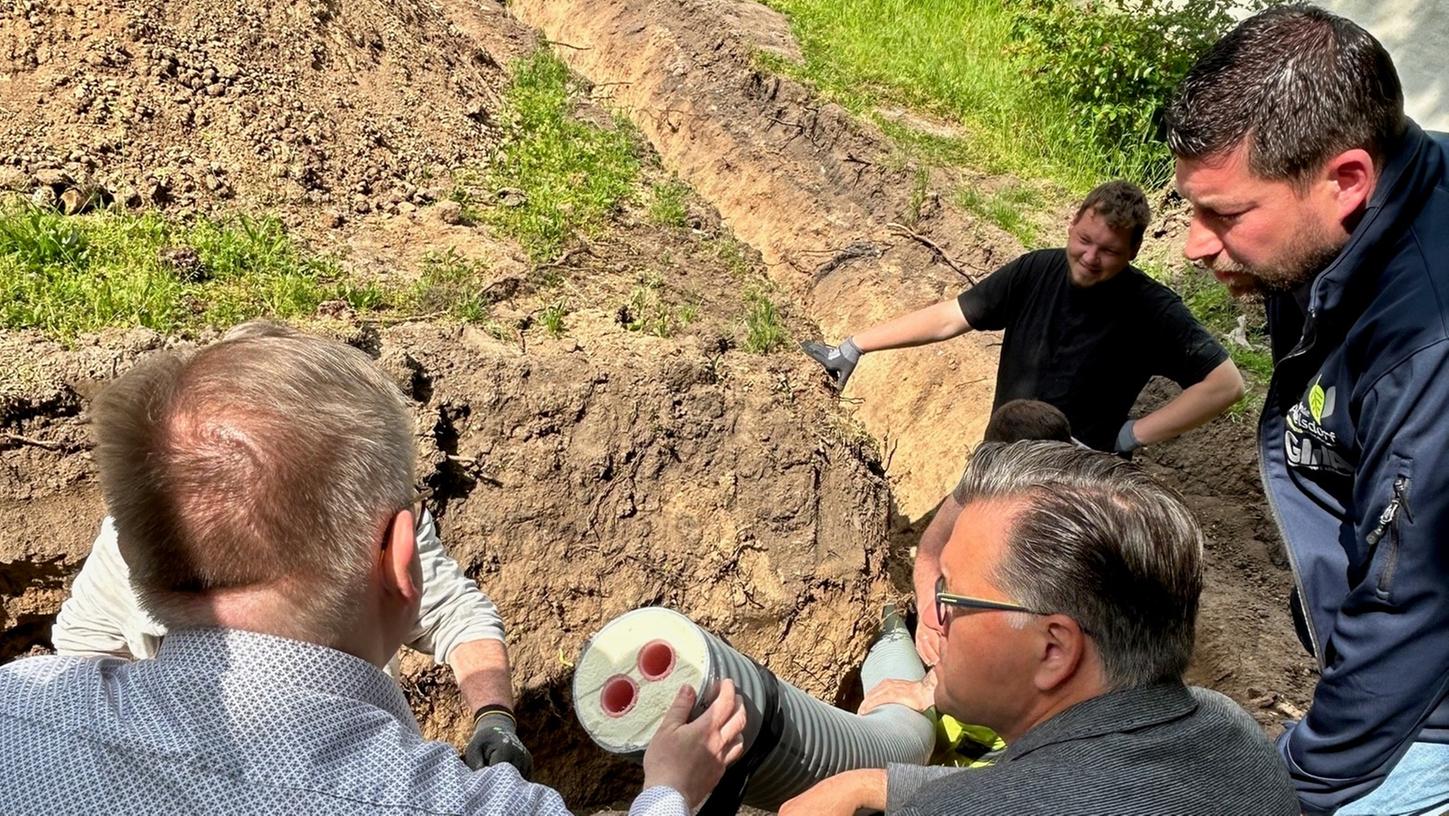 Adelsdorfs Bürgermeister Karsten Fischkal (M.) lässt sich erklären, wie die katholische Kirche Sankt Stephan an das Nahwärmenetz angeschlossen wird.