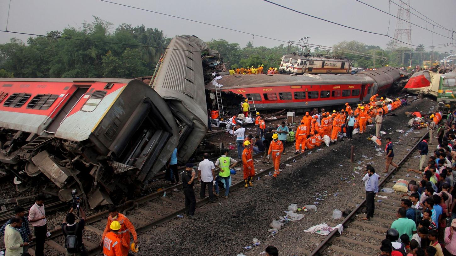 Rettungskräfte arbeiten an der Unfallstelle nach dem schweren Zugunglück im indischen Bundesstaat Odisha.
