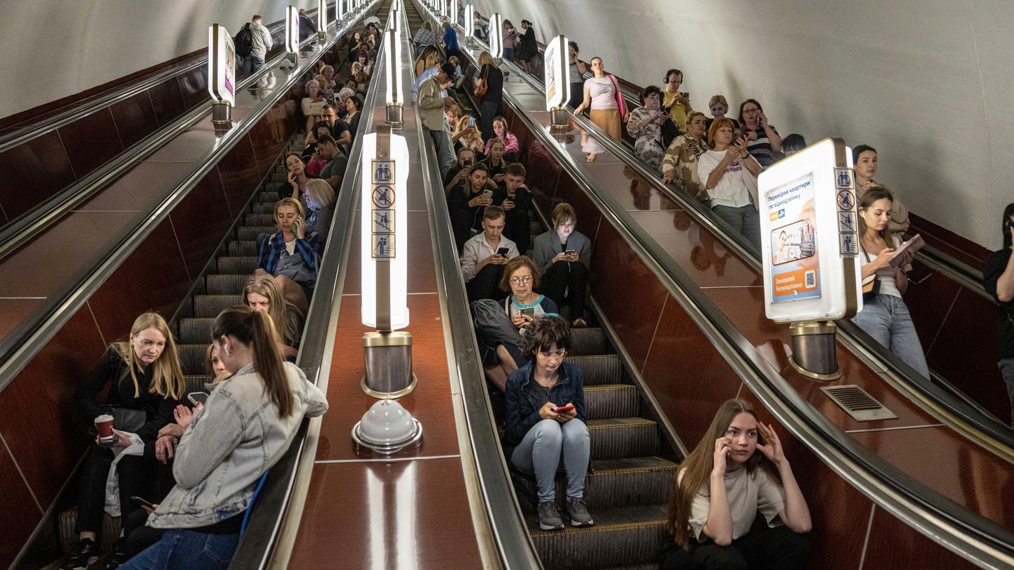 Menschen in Kiew sitzen auf einer Rolltreppe, während sie in einer Metrostation Schutz suchen. Die Ukraine bereitet sich weiter auf ihre Großoffensive vor, während sich die regulären Kämpfe auf den Donbass konzentrieren.