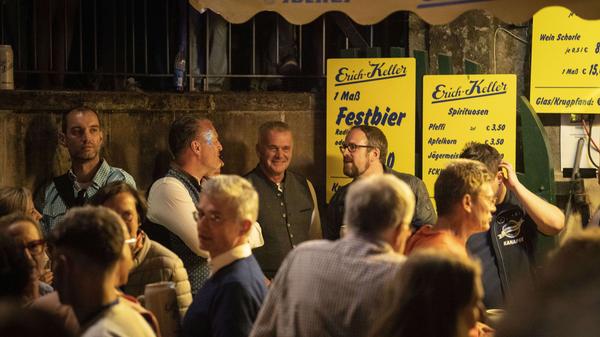 Oberbürgermeister Florian Janik wird sich bald den Weg zur Bühne bahnen, Kellerwirt Jorgos Liapouris bereitet sich auf das Fassbegräbnis vor.