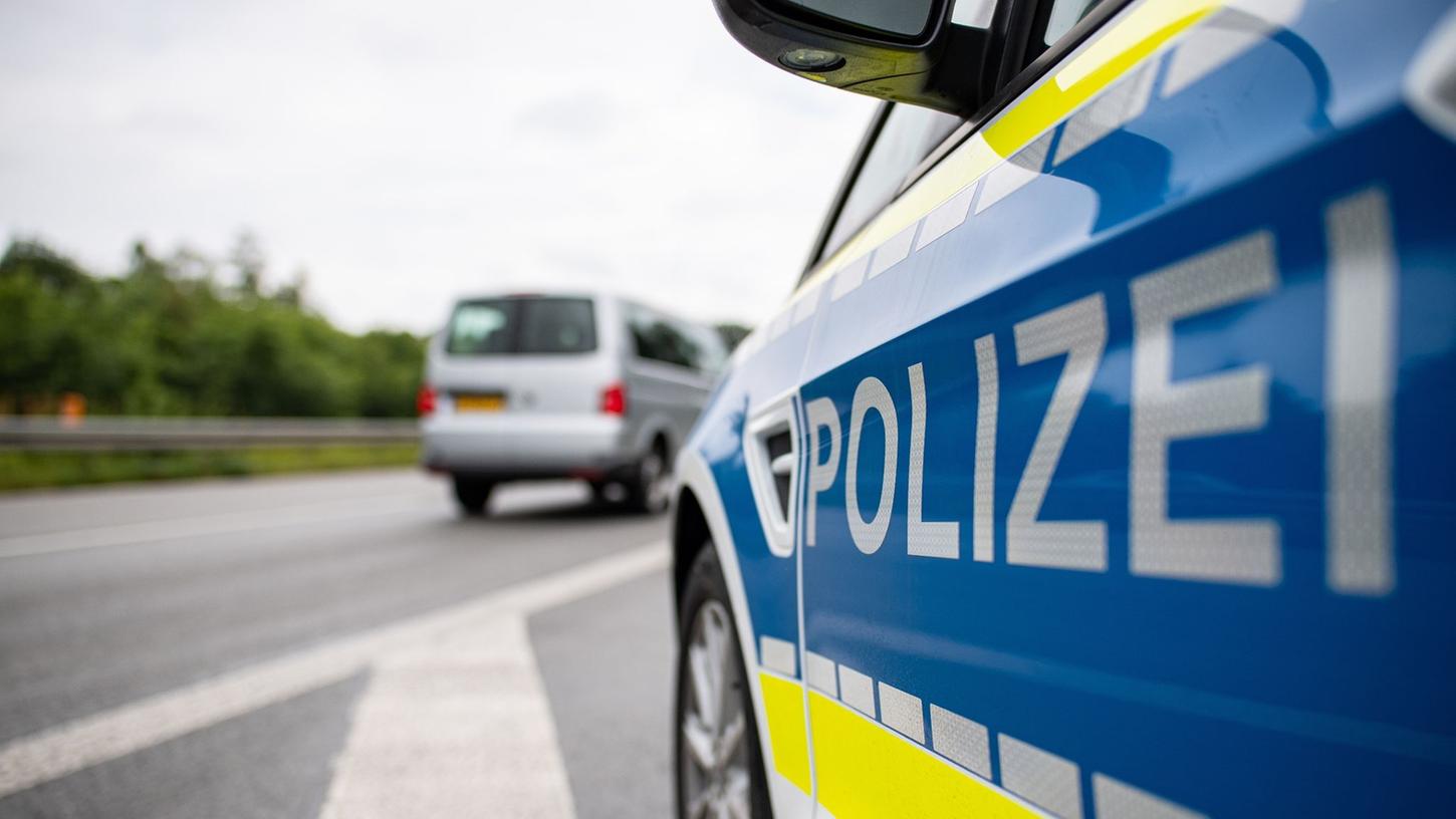 Ein Streifenwagen der Polizei steht auf einer Straße.