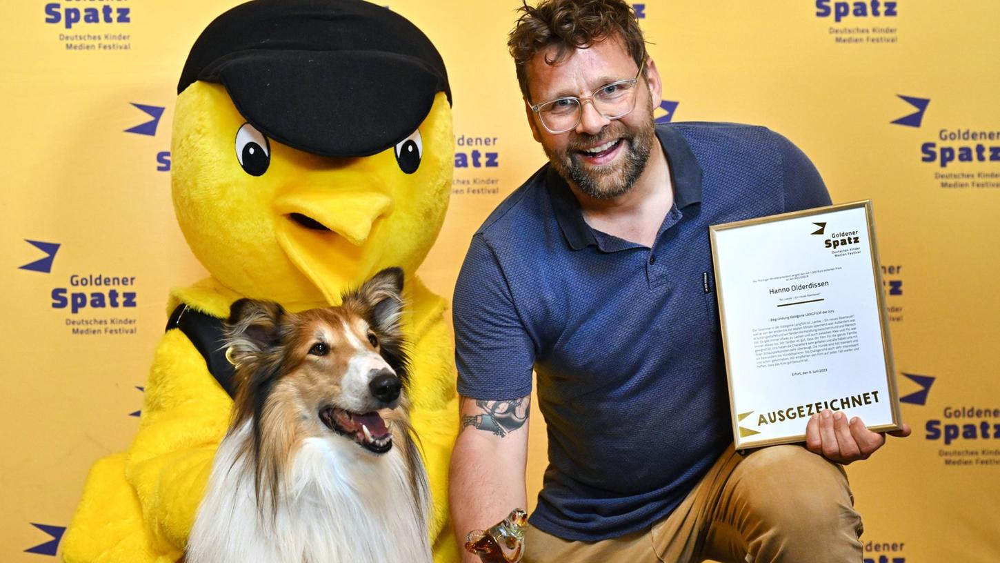 Der "Goldene Spatz", Filmhund "Bandit" und Regisseur Hannes Olderdissen freuen sich über die Auszeichnung für  "Lassie - Ein neues Abenteuer".