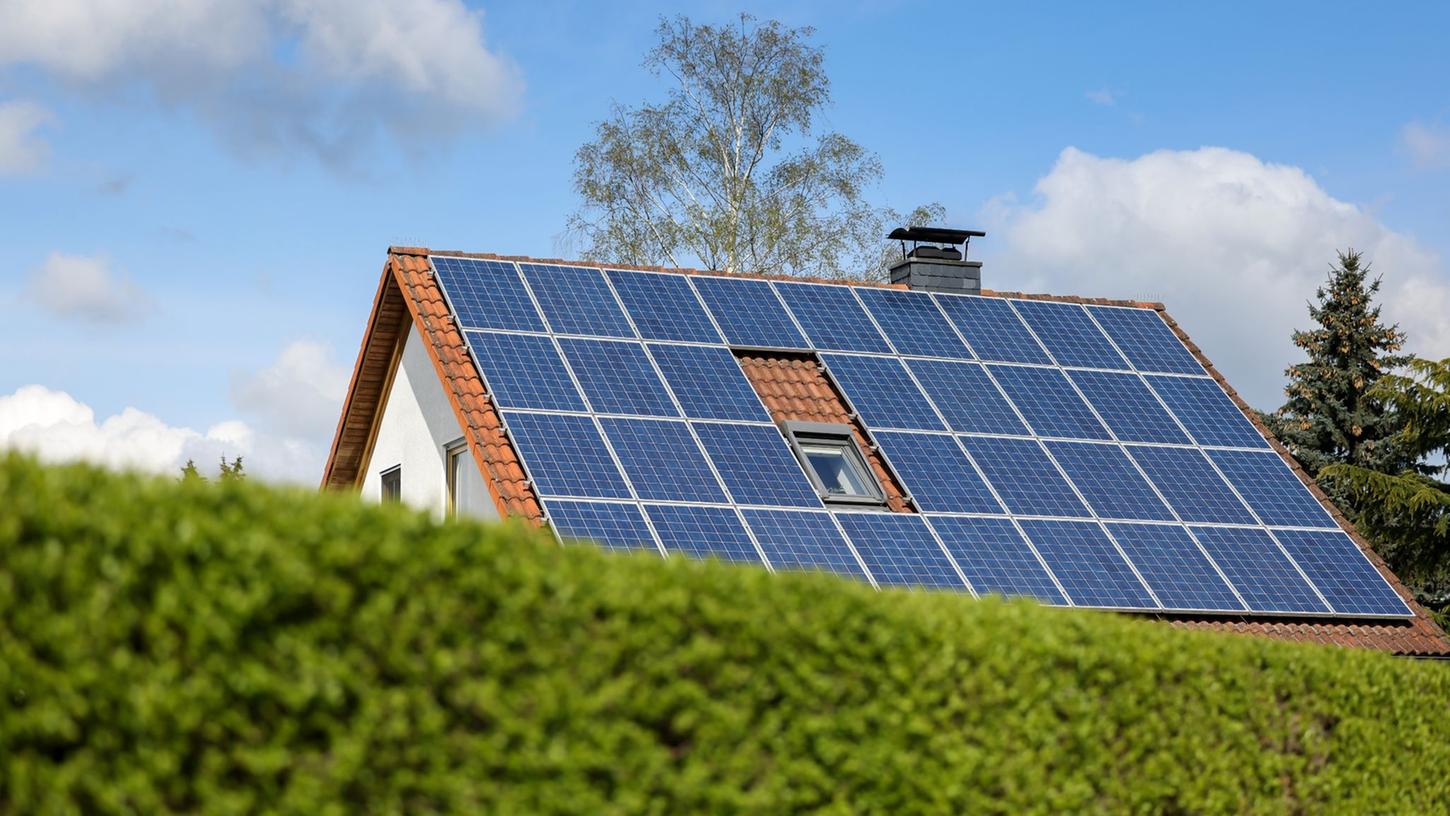 Solarpaneelen sind auf dem Dach eines Einfamilienhauses angebracht.