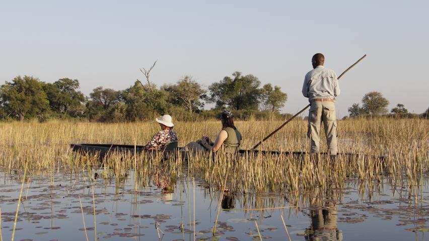 In Botswana können Touristen das Okavango-Delta in einem Einbaum-Boot erkunden.