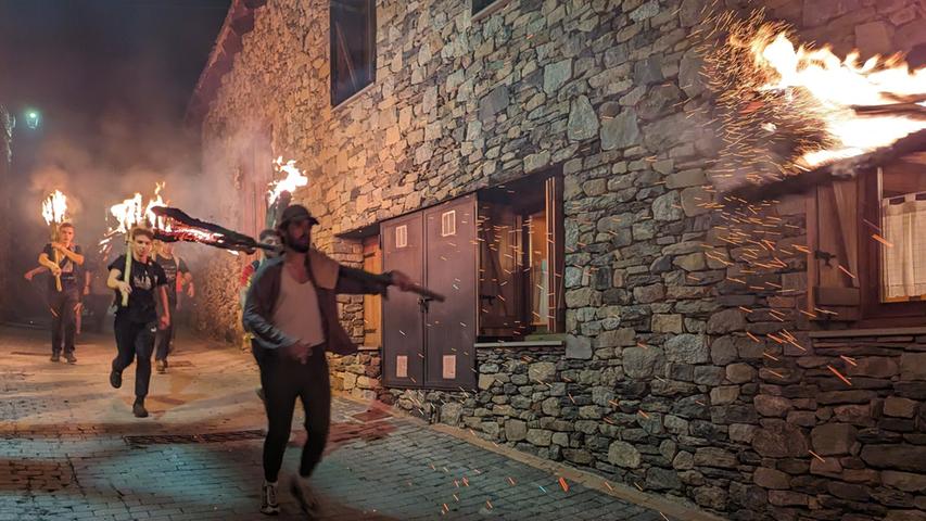 Feuerzauber vor alten Mauern: Im kleinen Bergdorf Durro im Vall de Boí rennen die "Falleros" mit ihren Fackeln durch die Straßen.
