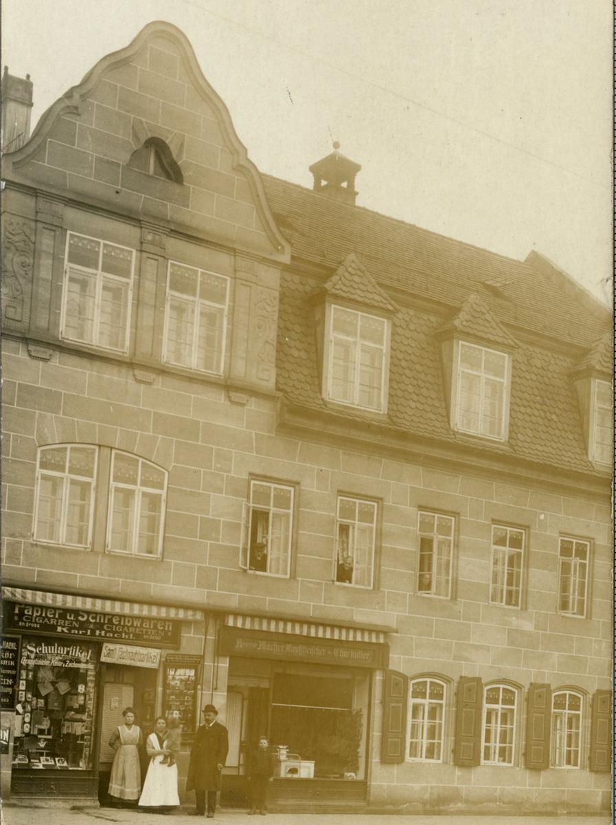 Um 1911 gönnten sich die Hackls eine Fotokarte ihres Hauses für Verwandte und Freunde. Links vor der Schreibwarenhandlung stehen Karl Hackl und seine Lieben.  
