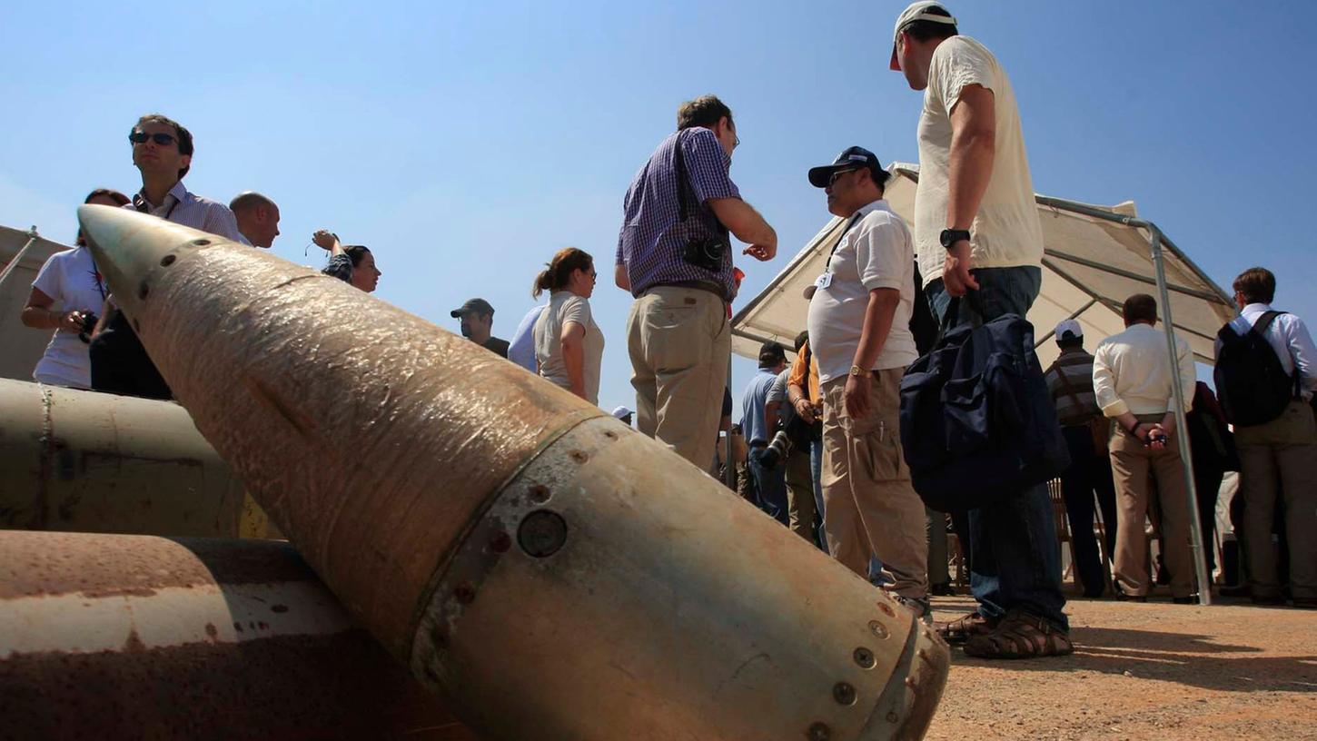 Aktivisten und Mitglieder internationaler Delegationen stehen neben Streubombeneinheiten während eines Besuchs auf einem libanesischen Militärstützpunkt.