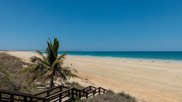 Cable Beach in Broome, Australien, ist ein atemberaubender Strand, der für seine unendlichen Weiten, goldenen Sand und spektakulären Sonnenuntergänge bekannt ist. Der Strand aus weißem, feinem Sand erstreckt sich über 22 Kilometer entlang der Küste. Die Umgebung von Cable Beach ist auch reich an natürlicher Vielfalt und kulturellem Erbe. Das nahegelegene Roebuck Bay ist ein wichtiger Lebensraum für Vögel und beheimatet eine Vielzahl von Arten, darunter Zugvögel. Darüber hinaus spiegelt die Geschichte von Broome, die eng mit der Perlenindustrie und der Kultur der Aborigines verbunden ist, eine faszinierende Mischung aus Tradition und Modernität wider.