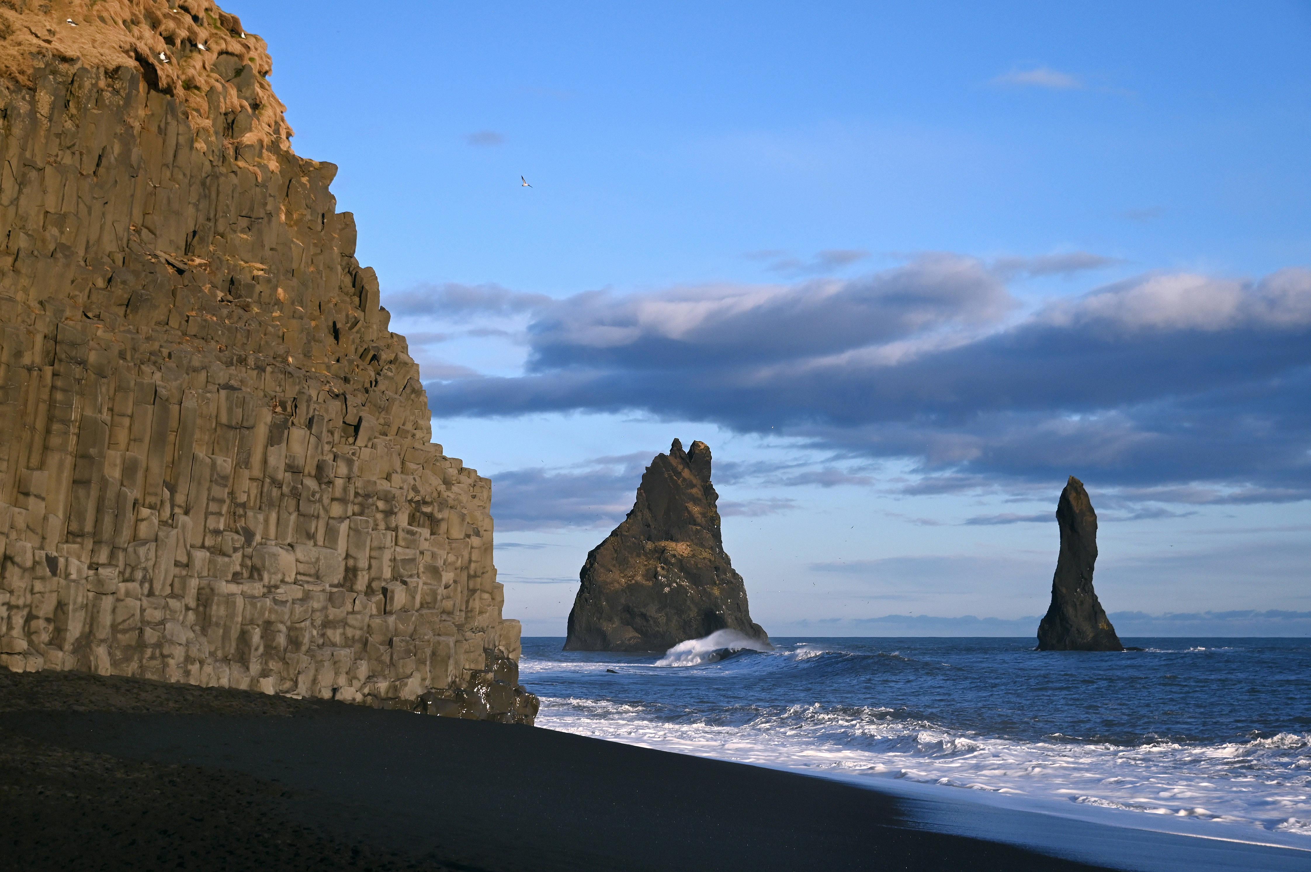 Reynisfjara Beach liegt in Vik, einem malerischen Küstenort an der Südküste Islands. Durch die Kombination aus dem schwarzen Sand, den imposanten Felsformationen und der interessanten Vogekolonie geraten Besucher und Besucherinnen von Reynisfjara in eine faszinierende und mystische Stimmung.
