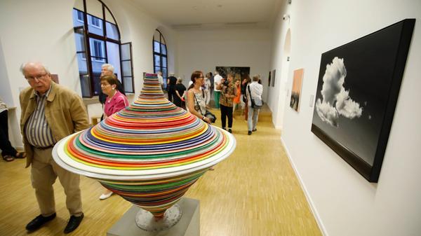 Der bunte Kreisel des Künstlers Harald Pompl besteht aus Harz, Pigmenten und Metall und entfaltet neben der Wolkenmalerei "Nordlicht" von Norbert Madsius im Kunsthaus seine Wirkung.
