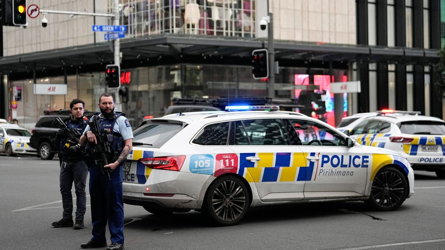 Bewaffnete neuseeländische Polizisten stehen an einer Straßensperre, nachdem in Auckland Schüsse gefallen waren.