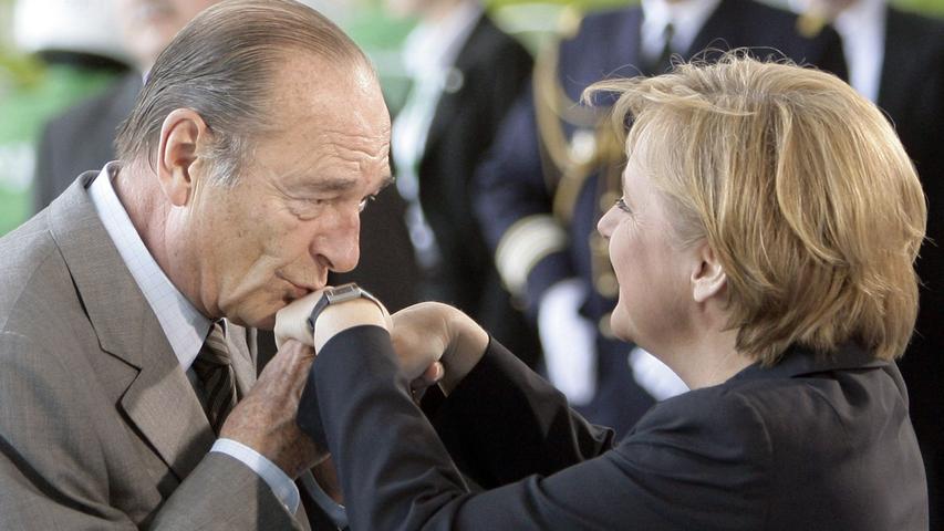 Ganz die alte Schule: Der frühere französische Präsident Jacques Chirac haucht einen Kuss auf den Handrücken von Angela Merkel. An diese Etiquette hielt sich Chirac bei jedem Treffen.