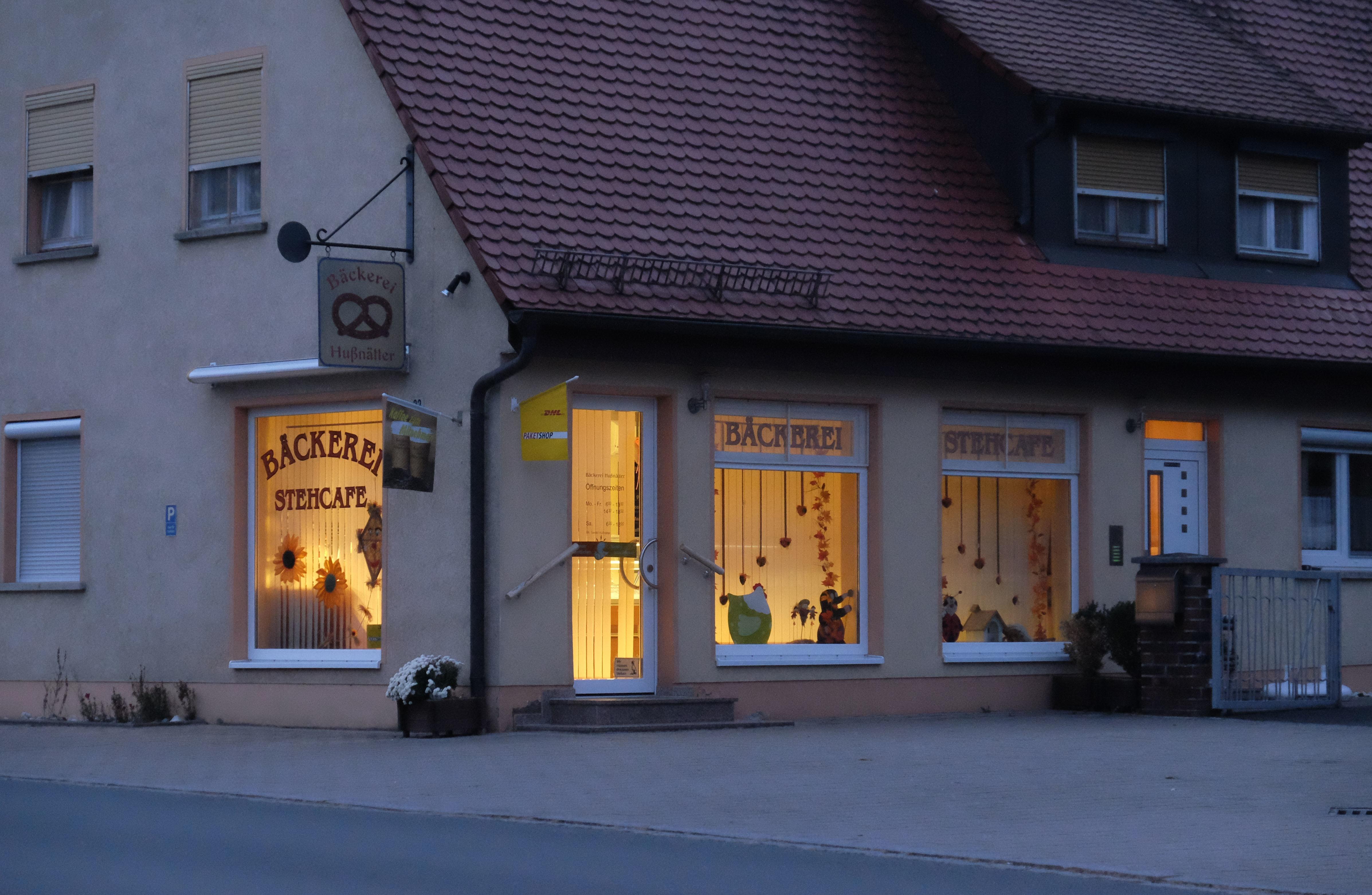 Die Bäckerei Hußnätter leuchtet am Abend.