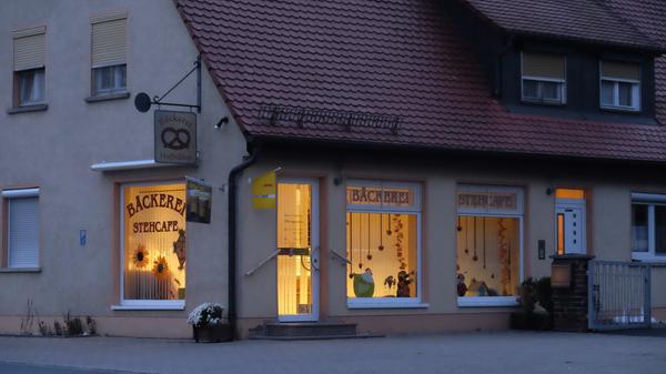 Die Bäckerei Hußnätter leuchtet am Abend.