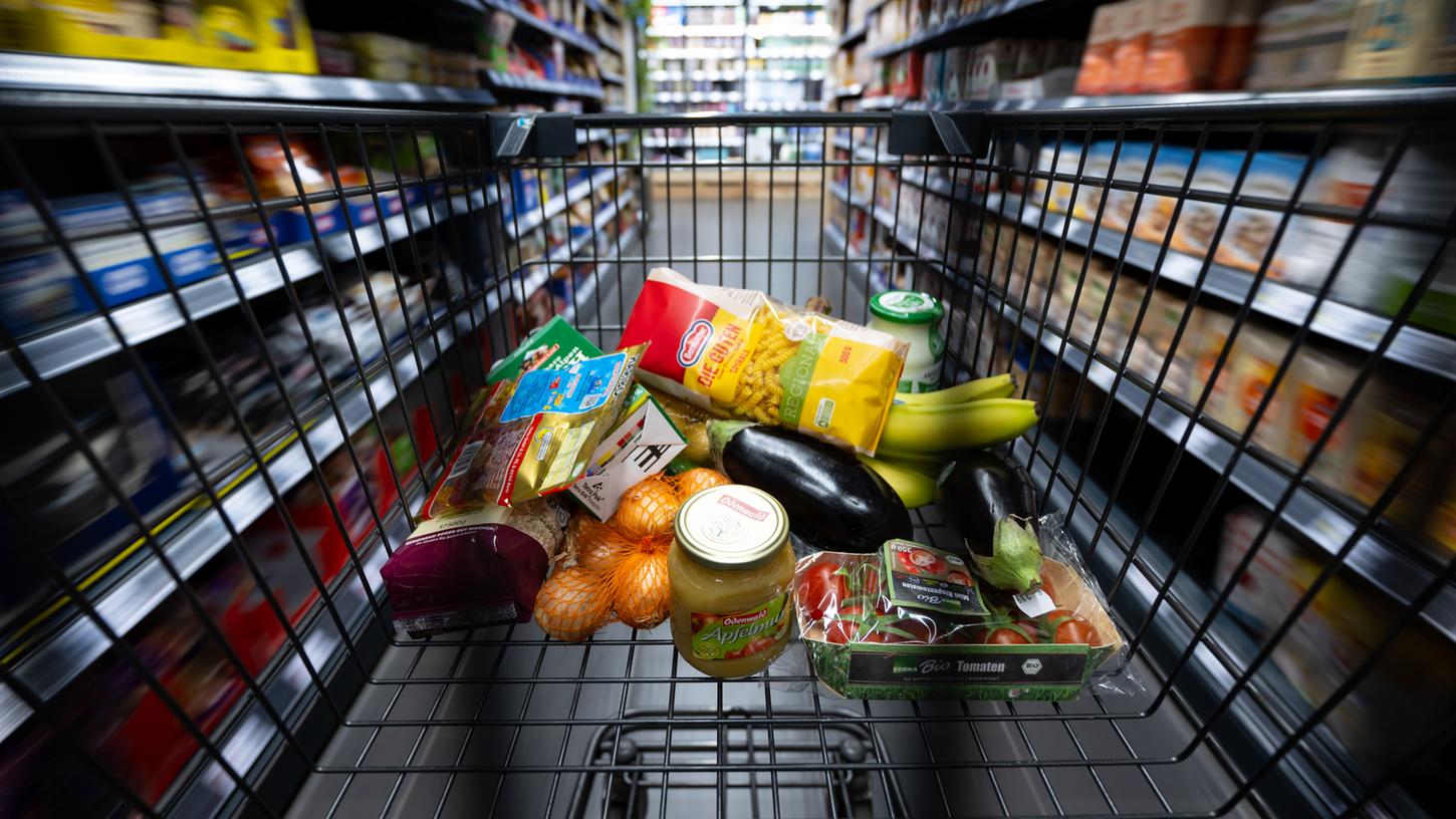Verschiedene Lebensmittel liegen in einem Einkaufswagen. Manchmal unterscheiden sich die Regal- von den Kassenpreisen - zum Ärger der Kunden.