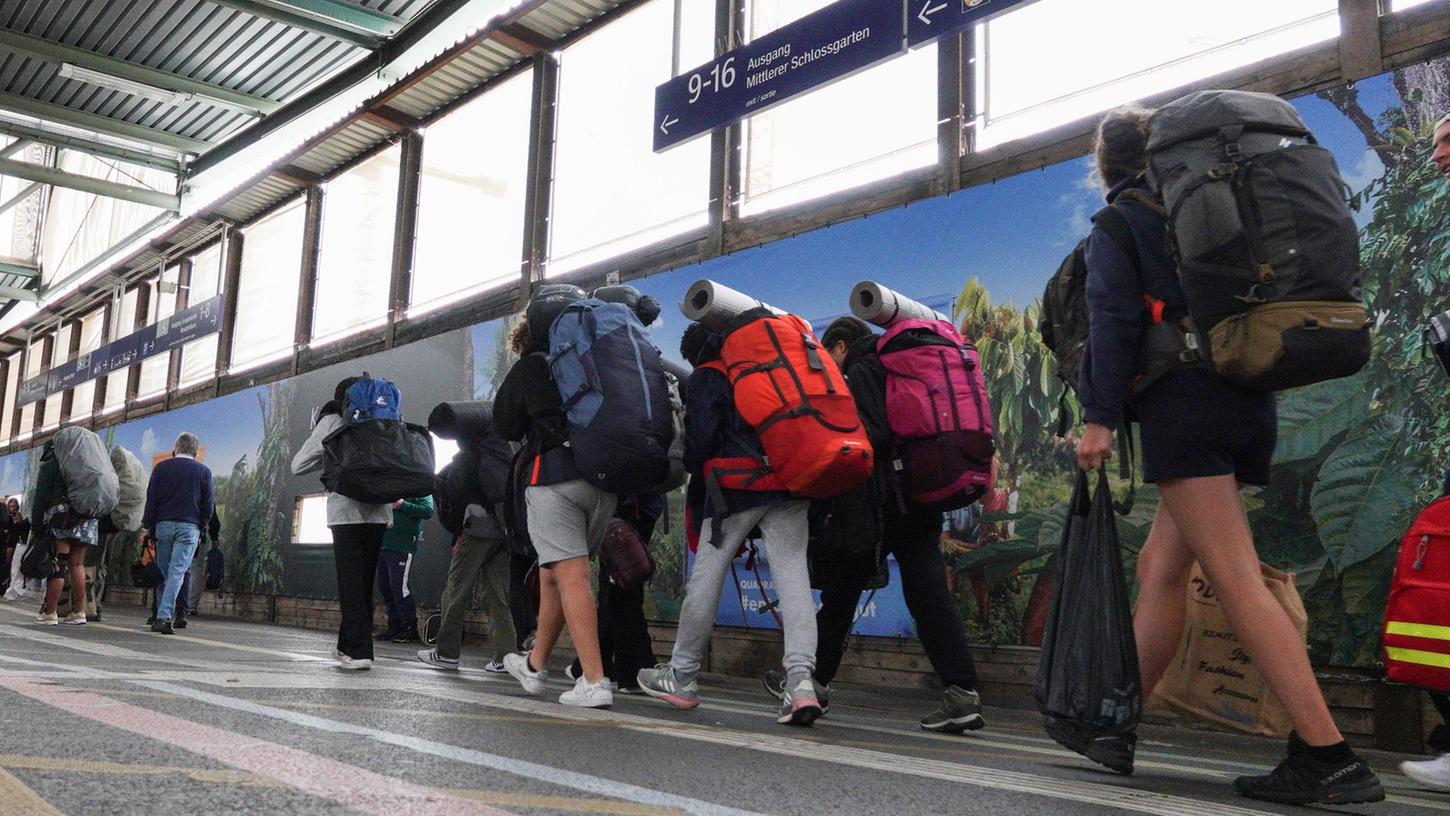 Fahrgäste mit Rucksäcken gehen am ersten Ferientag in Baden-Württemberg auf dem Hauptbahnhof in Stuttgart zu einem Zug.