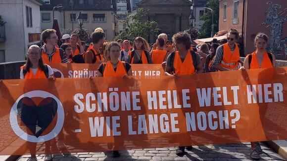 Mitglieder der "Letzten Generation" demonstrieren in Würzburg für eine konsequentere Klimapolitik.