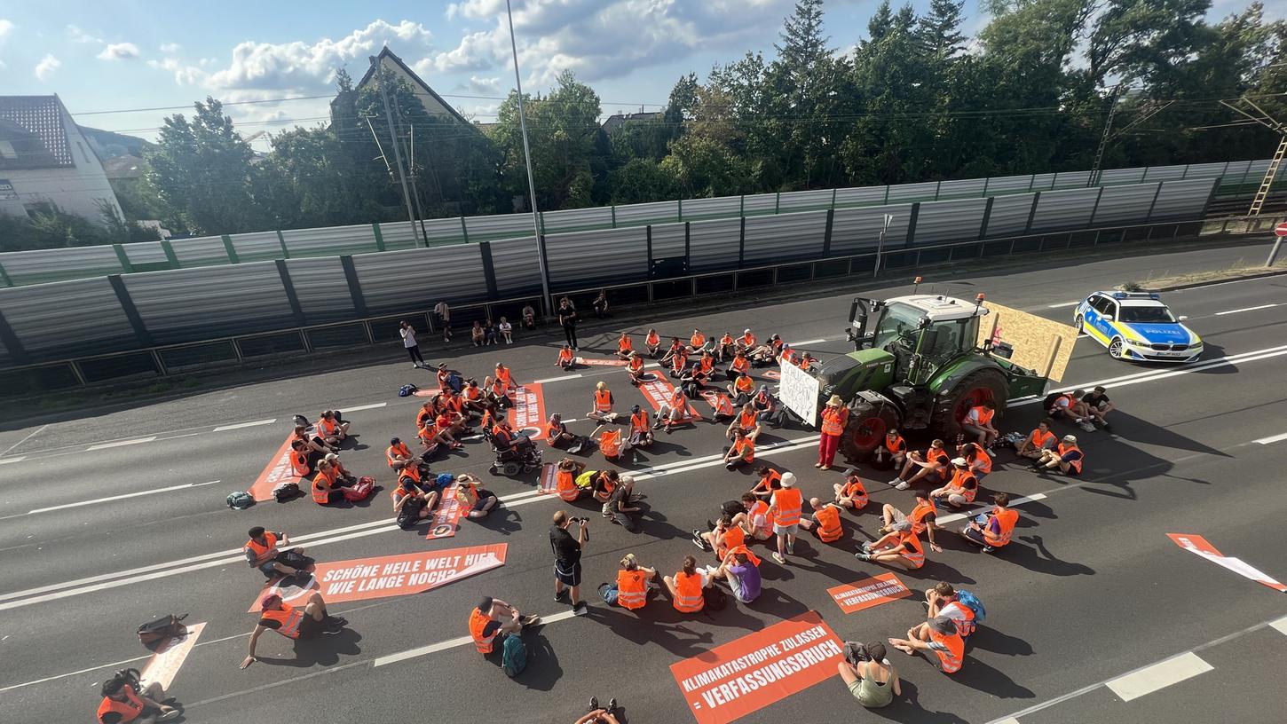 Unter anderem mit einem Traktor haben Klimaaktivisten der "Letzten Generation" am Dienstag in Würzburg die B19 blockiert. 