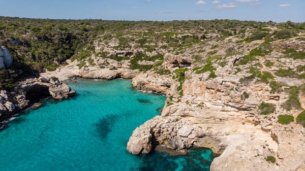Mallorca geht abseits von Ballermann und Schinkenstraße auch ganz ruhig und idyllisch. Im Nordosten der Insel befindet sich die Cala Màrmols, samt Sandstrand und türkisblauem Meer. Der Weg zur Bucht ist mit einer längeren Wanderung verbunden, die durch Kiefernwälder und vorbei an Klippen führt. Achtung: Die Pfade sind nicht ausgeschildert, deshalb die Wanderrouten unbedingt vorher online heraussuchen!