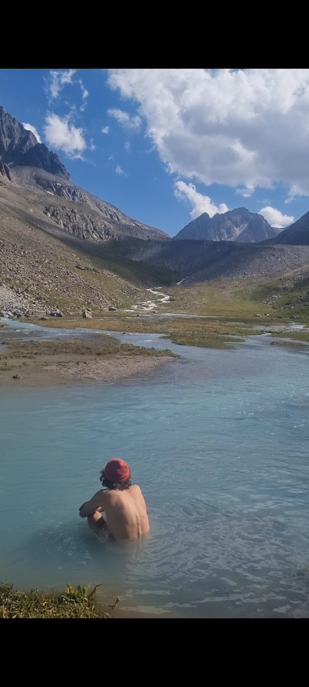 Ole genießt ein erfrischendes Bad im Gletscherfluss im Ala-Archa-Tal (Kirgistan).