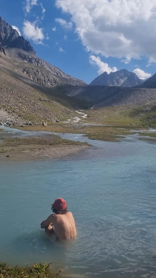 Ole genießt ein erfrischendes Bad im Gletscherfluss im Ala-Archa-Tal (Kirgistan).