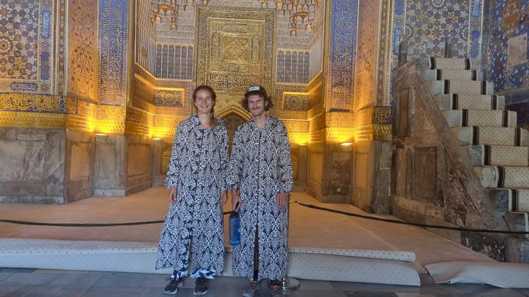 In einer Moschee in Bukhara tragen Pauline und Ole angemessene Kleidung. Diese wird häufig von den Moscheen zur Verfügung gestellt (Uzbekistan). Welche Tramping-Erfahrungen die Beiden auf ihren Reisen bisher gemacht haben, welche brenzligen Situationen sie erlebt haben und was sie raten unbedingt mitzunehmen, erfahren Sie im großen Interview auf NN.de.