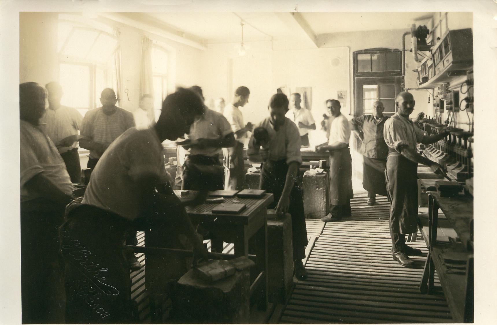 Die Urheber des Beinamens "Goldschlägerstadt": Eine Schwabacher Werkstatt mit Goldschlägern um das Jahr 1900. Links die Goldschläger an ihren Schlagsteinen, rechts Formenpresser. In die Formen (Bücher) wurden Goldfolien zum Schlagen eingelegt. Sie mussten unter den Pressen getrocknet werden.