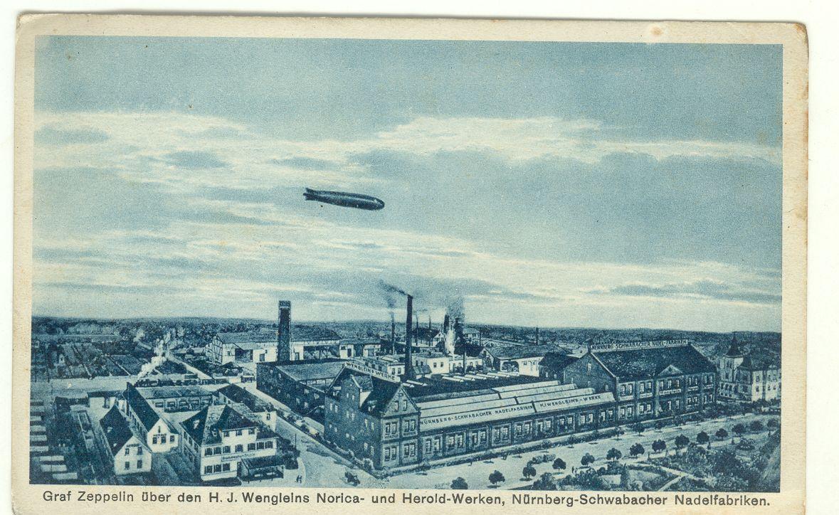 Die Nadelfabrik Wenglein machte Werbung mit dieser Postkarte vom Zeppelin-Überflug im Jahr 1909. Auf ihr sieht man das Luftschiff Graf Zeppelin über dem Werksgelände in der Bahnhofstraße (heute BayWa).