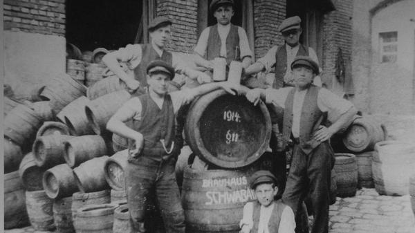 Mitarbeiter der Brauhaus Schwabach AG beim Freitrunk. Auf dem Fass stehen die Jahreszahl 1914 und "§ 11" - der bekannteste Paragraph in den Bier-Comments von Studentenverbindungen. Er lautet "Es wird weitergesoffen!" Schwabach war nie Studentenstadt, doch möglicherweise besteht ein Zusammenhang mit der Lehrerbildungsanstalt.