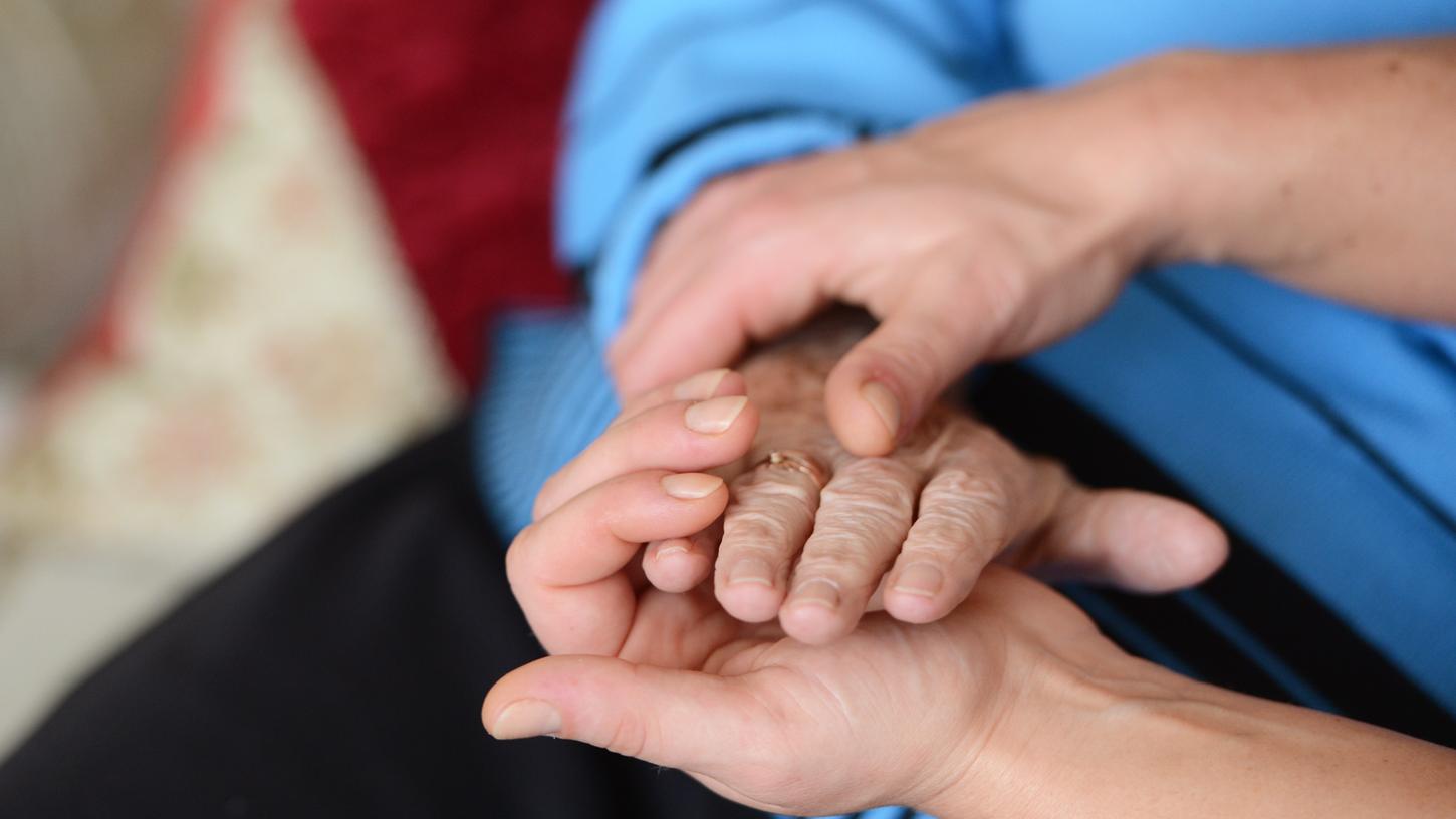 Eine junge Frau hält die Hand einer Seniorenheimbewohnerin. Laut einer Studie übernehm en auch viele Kinder und Jugendliche pflegerische Aufgaben in der Familie - darunter leiden oft Schulnoten und Privatleben. Der Pflegestützpunkt Altmühlfranken will helfen. Eine junge Frau hält die Hand einer Seniorenheimbewohnerin. Laut einer Studie übernehm en auch viele Kinder und Jugendliche pflegerische Aufgaben in der Familie - darunter leiden oft Schulnoten und Privatleben. Der Pflegestützpunkt Altmühlfranken will helfen.