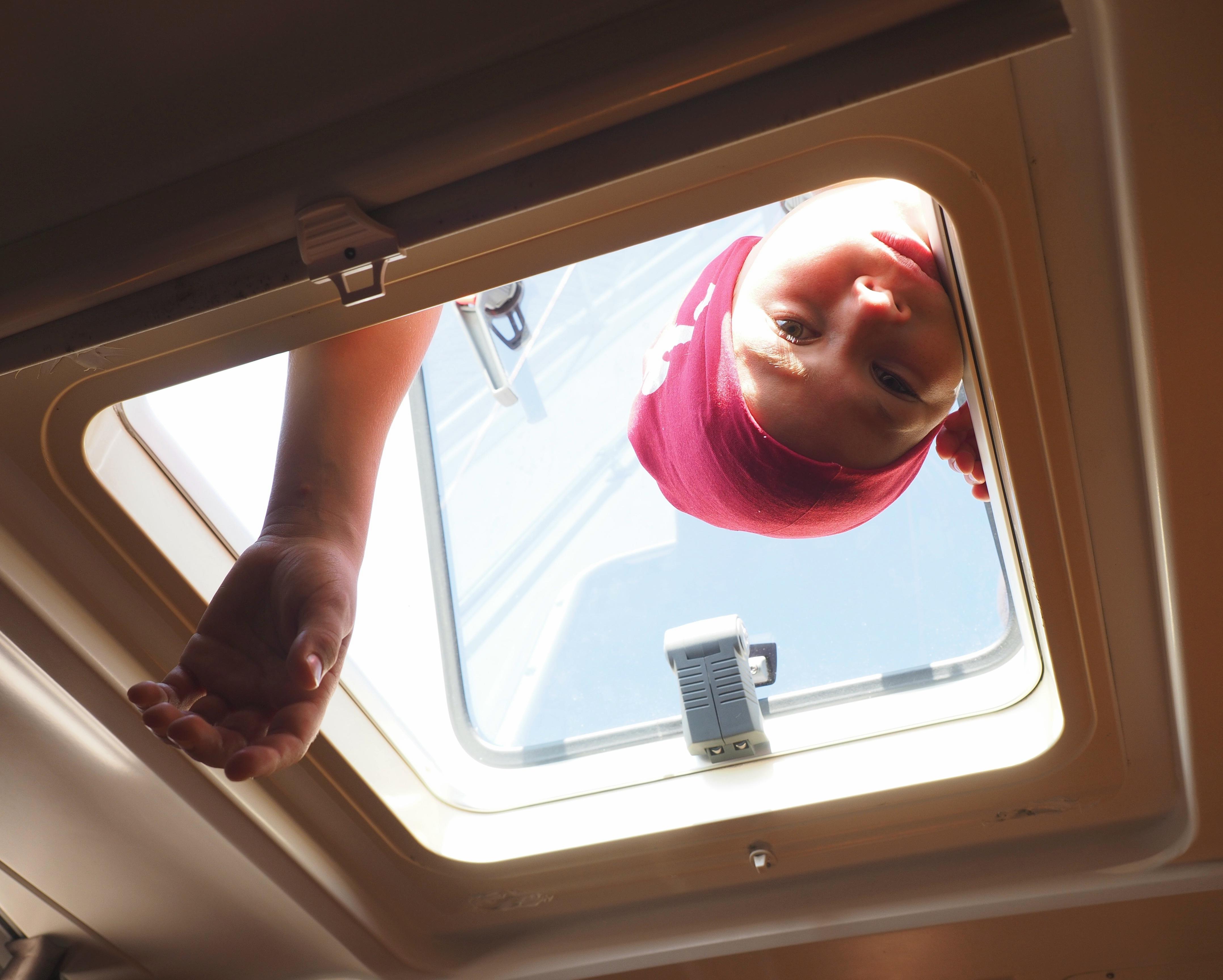 Neugieriger Blick eines Jungpiraten durch die Dachluke in eine Kabine.