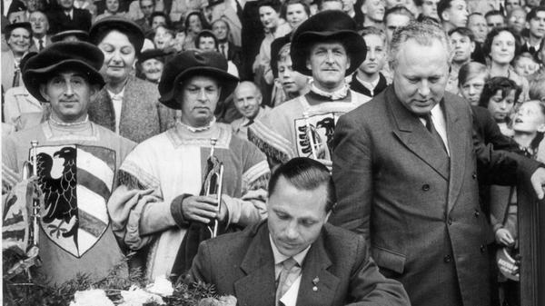 Auch von offizieller Seite wurde Morlock begeistert und mit hoher Wertschätzung in Empfang genommen. Hier trägt er sich in das Goldene Buch seiner Heimatstadt ein. Oberbürgermeister Otto Bärnreuther beobachtet den Club-Akteur aufmerksam.