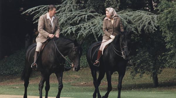 Der Alltag einer Königin: In den folgenden Jahren reist Elizabeth II. regelmäßig um die Welt oder empfängt Staatsoberhäupter in ihrer Heimat. Hier reitet sie im Jahr 1982 mit dem damaligen US-Präsidenten Ronald Reagan durch die Parkanlagen des Windsor Castle. Ob sich die beiden hier nur über Pferdewetten oder das herrliche britische Wetter austauschen, ist fragwürdig: Der Queen wird nachgesagt, dass sie durchaus Einfluss auf das politische Geschehen genommen habe.