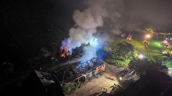 Flammenschein in der Nacht: Zwei landwirtschaftliche Hallen brennen nieder! - Feuerwehr schützt angrenzendes Wohnhaus und rettet Tiere - Unermüdlicher Kampf: Wasserversorgung stellt Feuerwehr vor große Herausforderung - 120 Einsatzkräfte verhindern größere Katastrophe - "Man sieht wieder, wie wichtig die kleinen Feuerwehren sind" - "Diese Riegelstellung hat dann erst einmal eine Zeit lang gebraucht, bis wir das Wasser da gehabt haben" - Erntevorräte, Maschinen und 60 Tonnen Weizen vernichtet - Ermittlungen zur Brandursache laufen auf Hochtouren