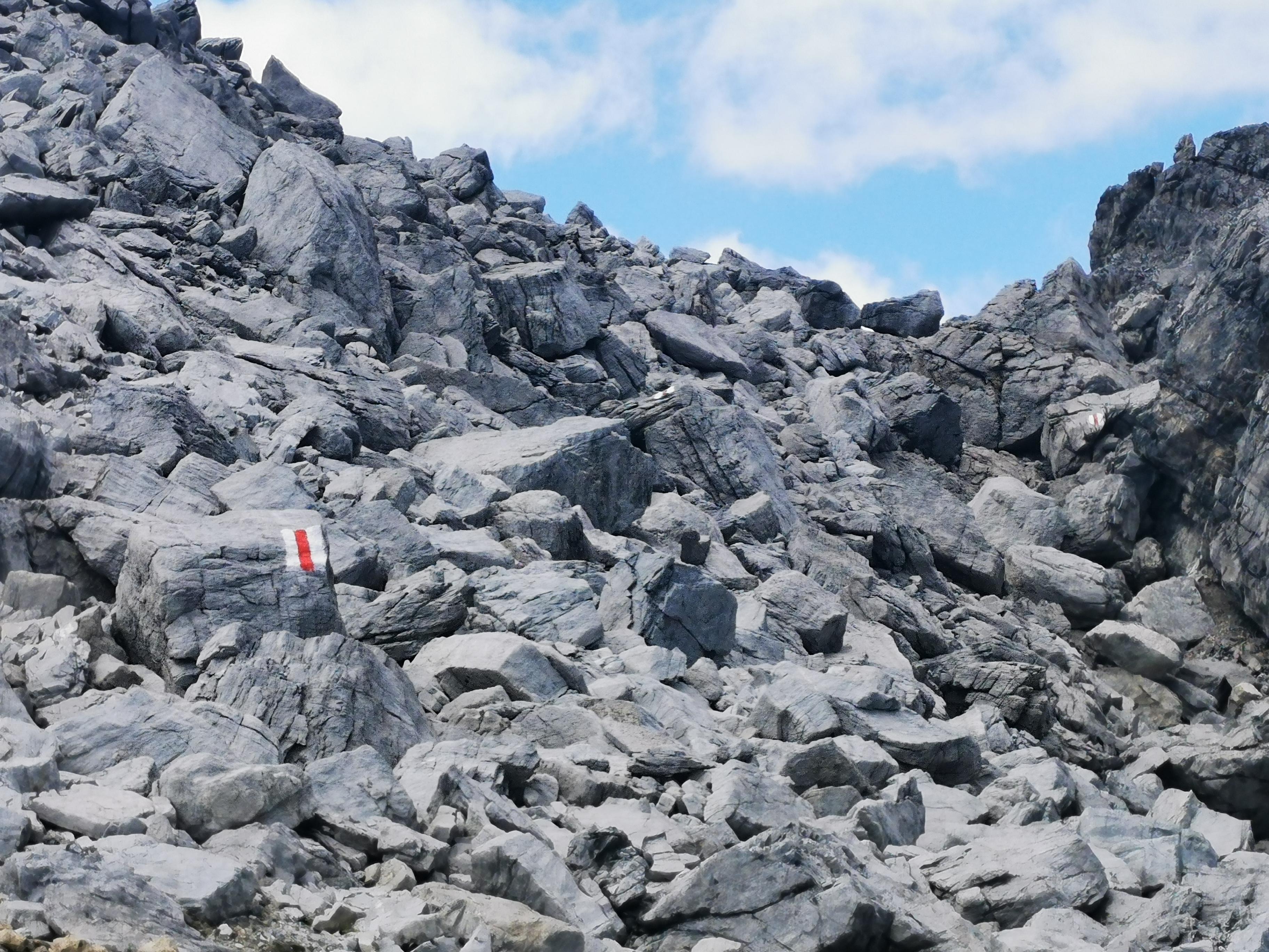 Rot-weiße Wegmarkierung, hier am Einstieg zum Orgelpass am Tinzerhorn im hochalpinen Geröll.