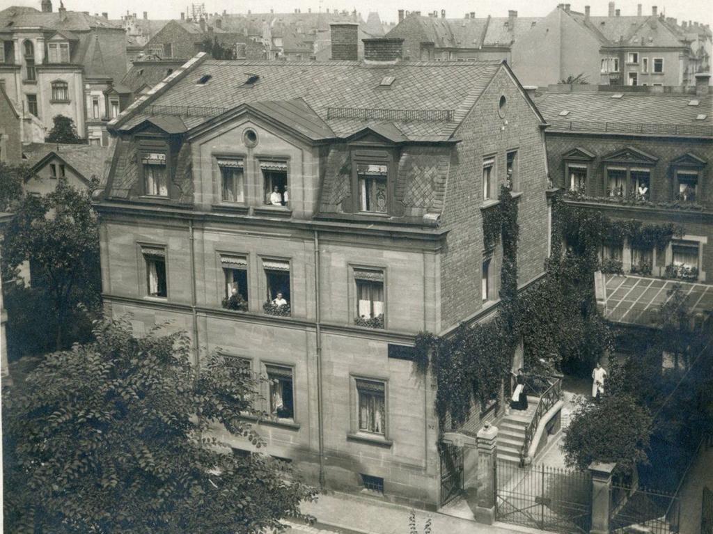 Von einem Fenster an der Hofseite des Hauses Maxfeldstraße 17 entstand 1912 diese Totale des Schiemerhauses. Im Hof sehen wir Hermann (im hellen Kittel) vor seinem Atelier. 