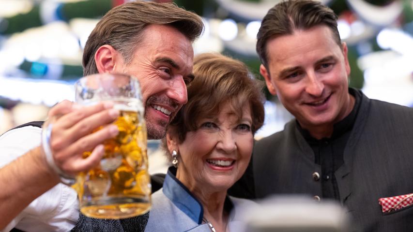 Florian Silbereisen (l-r), Carolin Reiber, und Andreas Gabalier, feiern in einem Bierzelt.