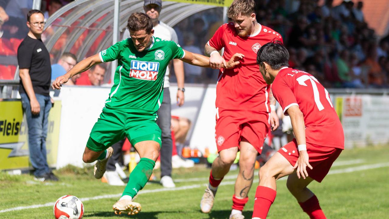 Dominik Wolfsteiner (grünes Trikot) setzt sich vor der Feuchter Bank gegen SC-Mittelfeldmann Damyan Opcin durch. Dominik Wolfsteiner (grünes Trikot) setzt sich vor der Feuchter Bank gegen SC-Mittelfeldmann Damyan Opcin durch.